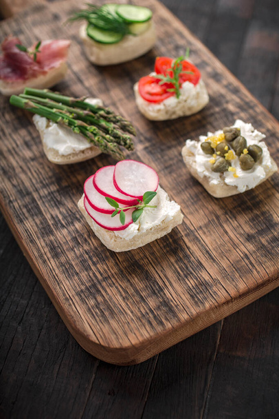 Set of different mini sandwiches on a wooden board. - Photo, Image