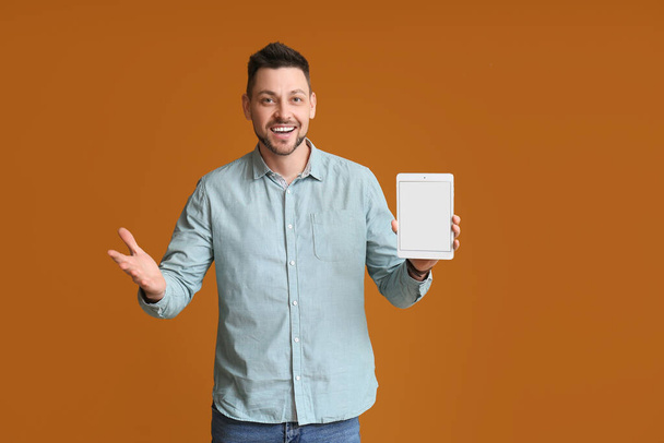 Hezký muž s počítačem tablet na barevném pozadí - Fotografie, Obrázek