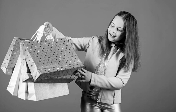 Happy child in shop with bags. Shopping day happiness. Buy clothes. Fashionista addicted buyer. Birthday girl shopping. Fashion boutique. Fashion trend. Fashion shop. Little girl with bunch packages - 写真・画像