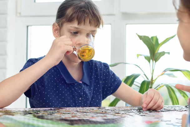 Girl drinks water playing board games at the table - Photo, Image