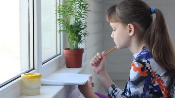 Девушка рисует у окна карандашом в альбоме
 - Кадры, видео