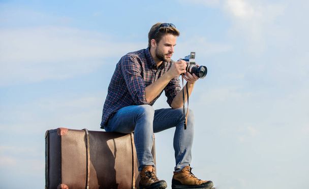 Get out there. macho man with camera on baggage. photographer in glasses. capture adventure. journalist. sexy man touristic reporter. traveler wait for car. male fashion style. looking trendy - 写真・画像