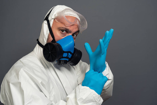 portrait of unrecognizable disinfector in gas-mask, male in protective suit, ready to get rid of bacterias and clean contaminated areas. coronavirus, COVID-19 epidemic concept - Foto, Imagem