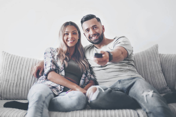 Young couple enjoying themselves on the sofa in the living room - Photo, Image
