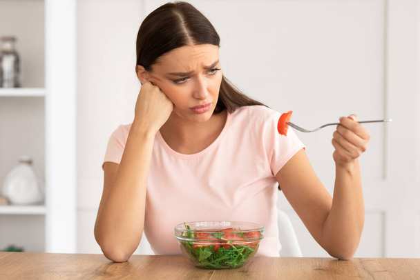 Smutna dziewczyna Jedzenie sałatki warzywnej utraty wagi w domu - Zdjęcie, obraz