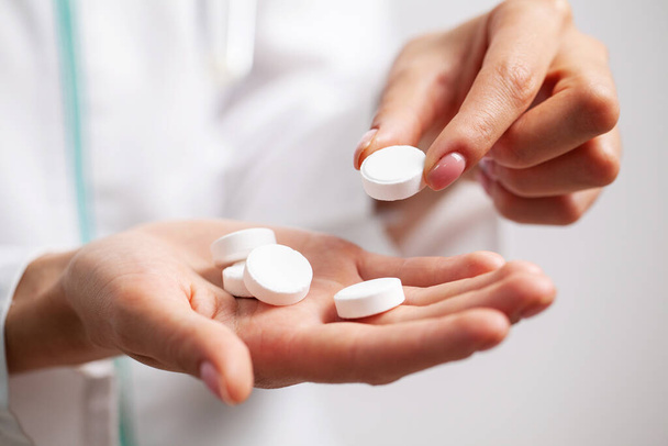 Doctor close up holding white pills for weight loss - Photo, Image