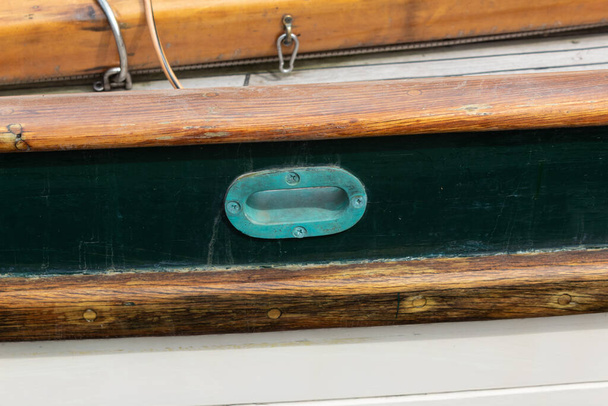 Παλιό χάλκινο γεράκι σε ένα παλιό ιστιοφόρο, παλιό ξύλινο σκάφος, βαρύ verdigris patina, οριζόντια όψη - Φωτογραφία, εικόνα