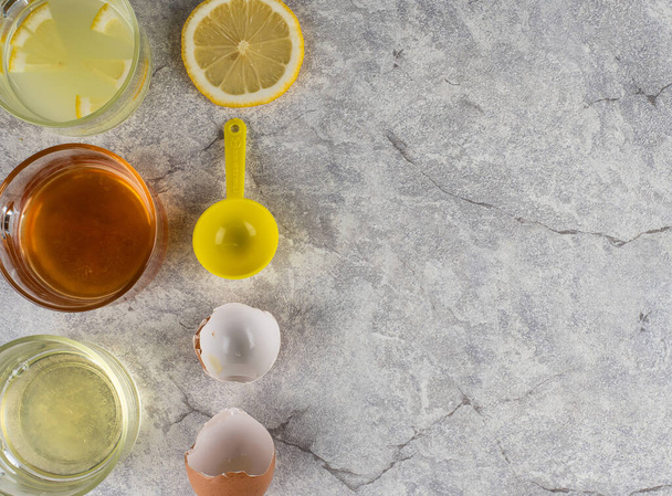 レモン、蜂蜜、卵を使用して手作り洗顔白いコンクリートの背景にオーバーヘッドビューに白いフラットレイアウト   - 写真・画像