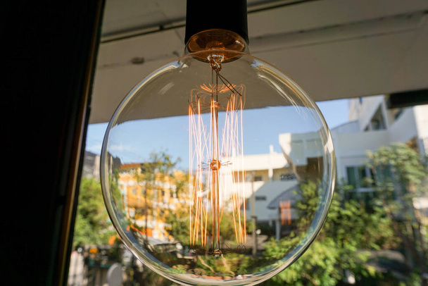 Corrente elétrica espiral incrível dentro de uma lâmpada clara de cristal retro
. - Foto, Imagem