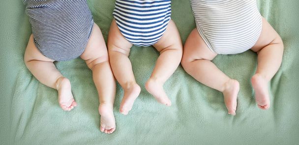 新生児の三連は毛布の上に胃の上にあります - 写真・画像