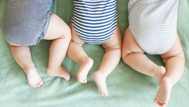 Os trigêmeos recém-nascidos estão em um estômago em um cobertor
 - Foto, Imagem
