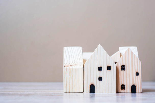 テーブルの上の木製の家モデル。ホーム、危機、景気後退、開発者、不動産、購入または賃貸、不動産の概念 - 写真・画像