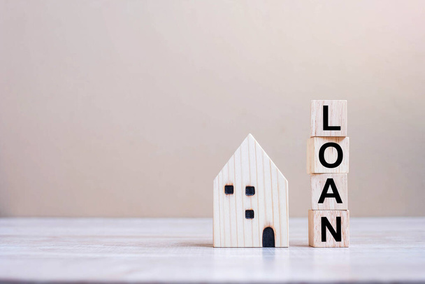LOAN cube blocks with wooden house model on table background. fall Business, investment, Crisis, Economic recession, Developer, Real Estate and Property concept - Foto, imagen