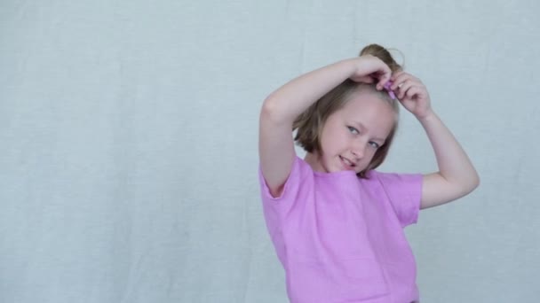 Girl posing for the photographer, raising his hands up to the head. Image on a light background - Filmmaterial, Video