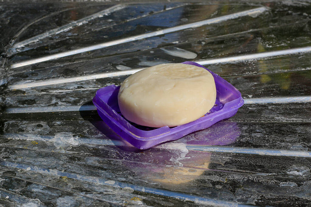 Gros plan du savon, placé sur un plancher en acier inoxydable avec une classe sale
. - Photo, image
