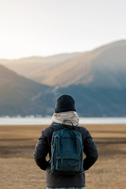 Hipster woman traveler with sweater and backpack traveling at Napa Lake, Happy young Hiker looking mountain and sunset in trip Shangri-La,Yunnan,China. Explore, Adventure and Asia Solo travel concept - Photo, Image