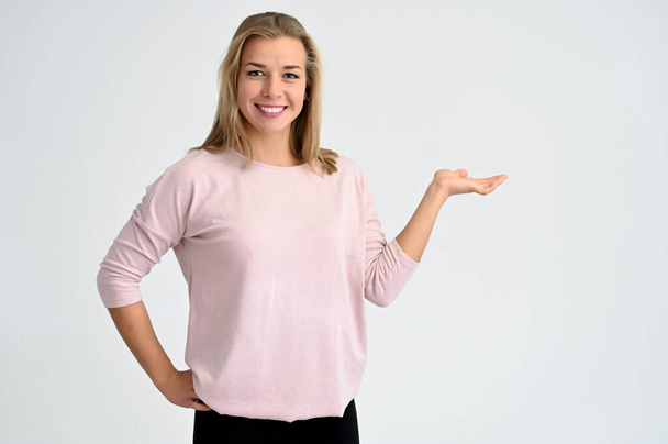 Close-up portrait of a cute caucasian blonde female student girl in pink blouse on a white background. Wide smile, happiness. It is in different poses. - Valokuva, kuva