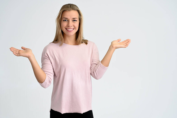 Close-up portrait of a cute caucasian blonde female student girl in pink blouse on a white background. Wide smile, happiness. It is in different poses. - Fotó, kép
