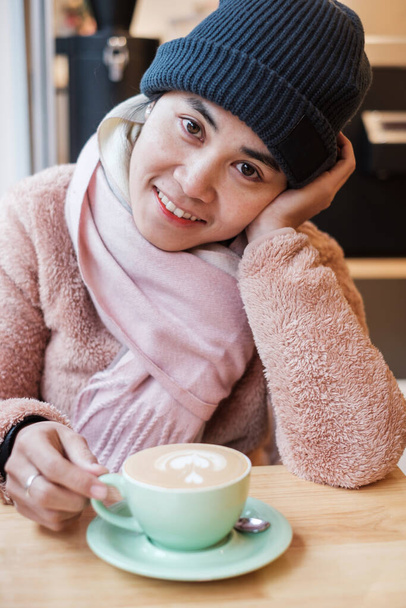 Happy woman with sweater enjoy during drinking hot coffee in cafe shop - Foto, Imagem