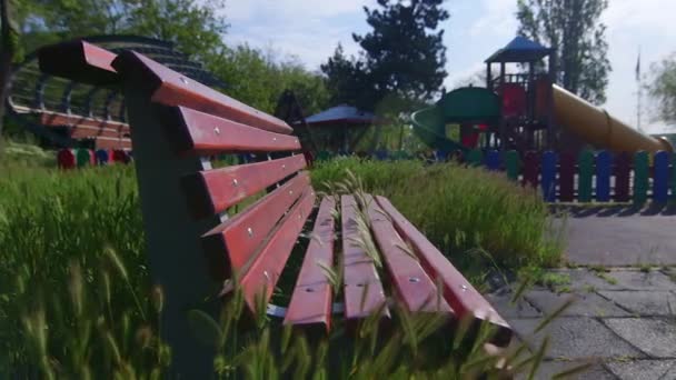 Пустая скамейка на детской площадке закрыта из-за пандемического вируса Ковид-19, коронавирус - Кадры, видео