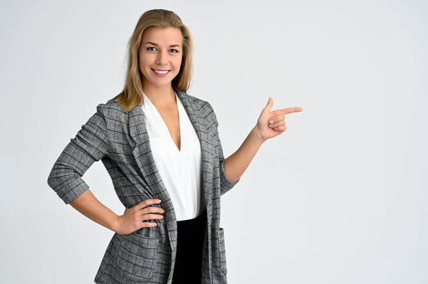 Close-up portrait of a cute caucasian blonde female student girl in a gray jacket on a white background. Wide smile, happiness. It is in different poses. - Photo, Image
