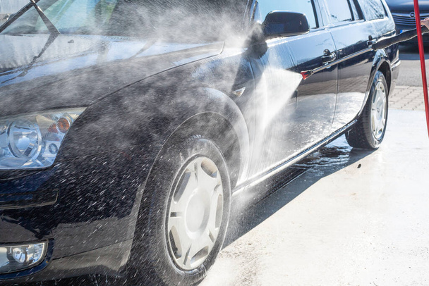 Χειροκίνητο πλύσιμο αυτοκινήτων, καθαρισμός χρησιμοποιώντας νερό υψηλής πίεσης στο πλυντήριο αυτοκινήτων, έννοια καθαρισμού - Φωτογραφία, εικόνα