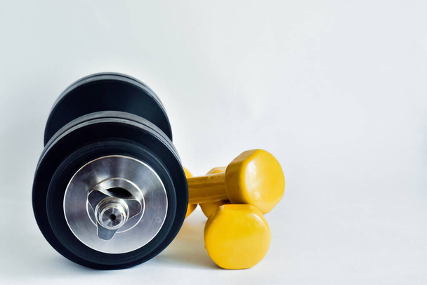playing sports at home.dumbbells for sports. different sizes. big and small on a white background. place for text. - Foto, Imagen