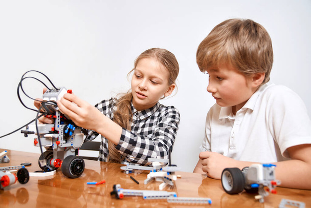 Young friends creating robot using building kit. - Zdjęcie, obraz