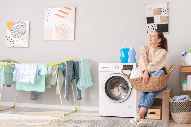 молода жінка робить прання вдома
 - Фото, зображення