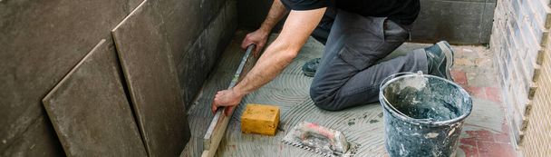 Bricklayer checking floor with a level - Photo, Image
