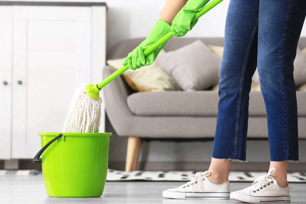 Woman mopping floor in room - Foto, Bild