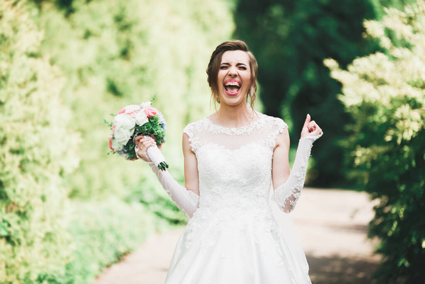 Luxury wedding bride, girl posing and smiling with bouquet - Foto, imagen