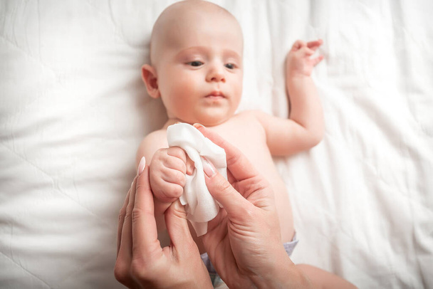 Onderwerp Hygiëne reinigingsdoekje, zuiver, schoon. jong momy na douche baby verpakt in handdoeken op de luier tafel. - Foto, afbeelding