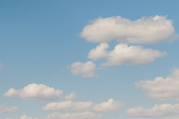 Blauwe zonnige lucht, witte Cumulus wolken onderste laag van wolkendek, lucht achtergrond . - Foto, afbeelding