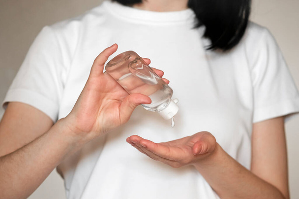 Nahaufnahme einer Frau mit antibakteriellen Desinfektionsmittel Gel in Flasche auf den Händen. - Foto, Bild