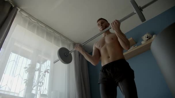 guy exercising in with barbell in a living room - Video