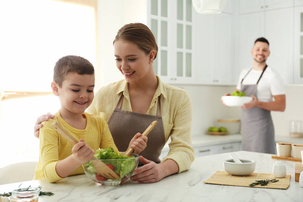 Happy family cooking salad together in kitchen - Zdjęcie, obraz