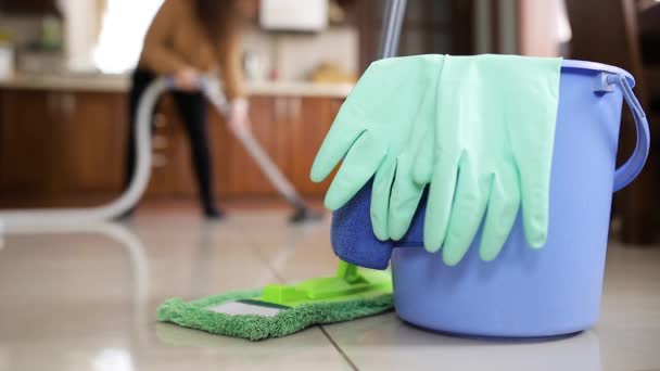 家庭用掃除用品。女の子ダンスとともに真空クリーナーで彼女の手クリーニングザ床でザキッチン - 映像、動画