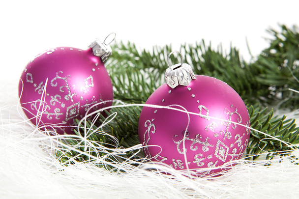 白い背景の上の 2 つのピンクのクリスマス ボールと松の木 - 写真・画像