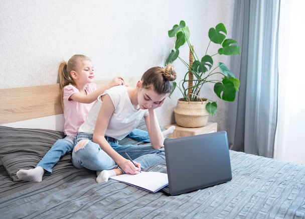 Uczennice uczą się w domu za pomocą laptopa. Zostań w domu. Edukacja online, edukacja domowa, koncepcja kwarantanny - Zdjęcie, obraz