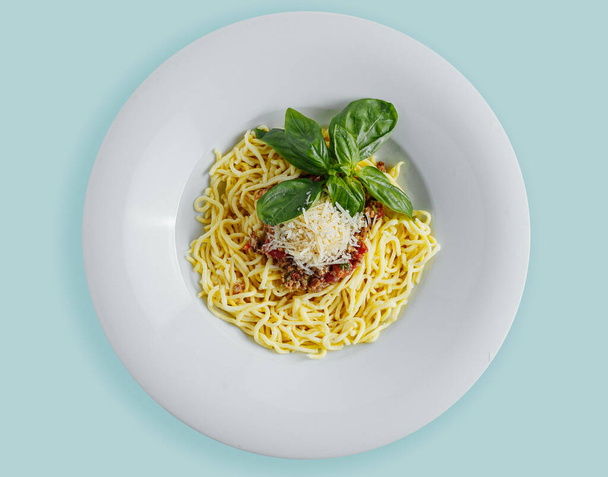 spagetti bolognai fehér tányéron, széles mezőkkel, fehér háttérrel. Felül. felülnézetből - Fotó, kép
