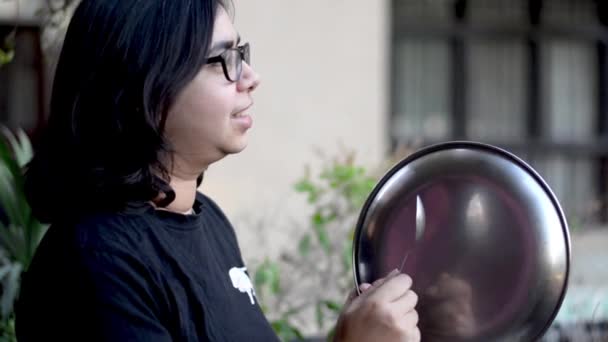 Young Indian girl making noise with a plate and spoon as a mark of respect for essentia l healthcare workers, medical personel, doctors, policemen and more during the coronavirus lockdown in India - Footage, Video