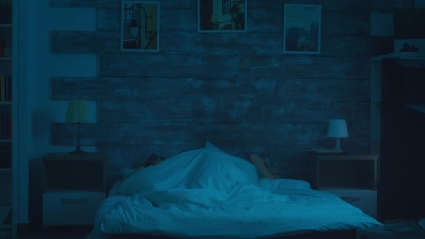 Młody mężczyzna budzi swoją dziewczynę po strasznym koszmarze - Materiał filmowy, wideo