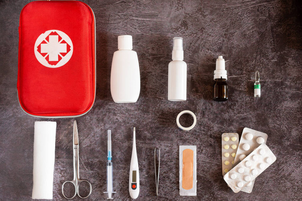 Home EHBO kit, pillen, thermometer op eenvoudige achtergrond - Foto, afbeelding