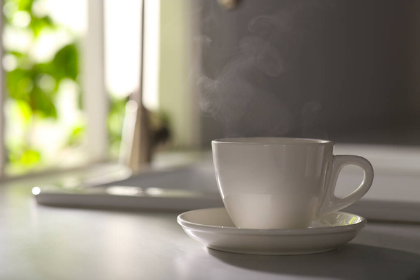 Xícara de café delicioso na bancada da cozinha, espaço para texto. Bom dia.
 - Foto, Imagem