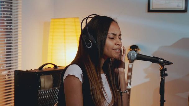 Fekete női énekes fülhallgatóban felveszi új dalát a stúdióban - Fotó, kép