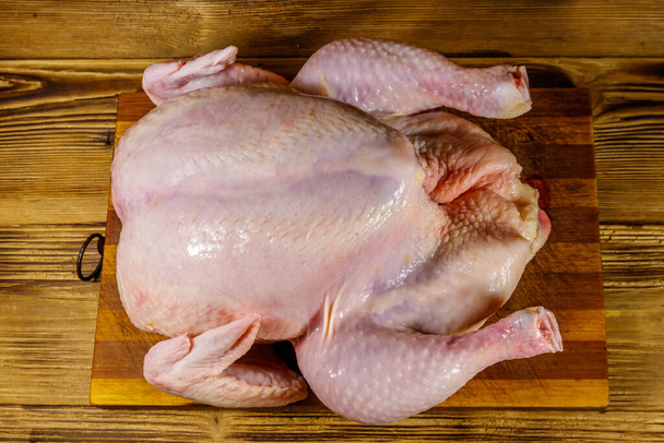 Raaka kokonainen kana puupöydällä. Yläkuva - Valokuva, kuva