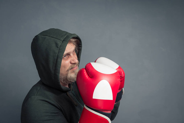 Portrait of a guy in a hoodie and Boxing gloves. - Фото, зображення