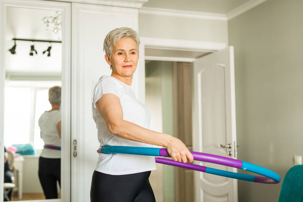 beautiful elderly woman goes in for sports at home - Photo, image