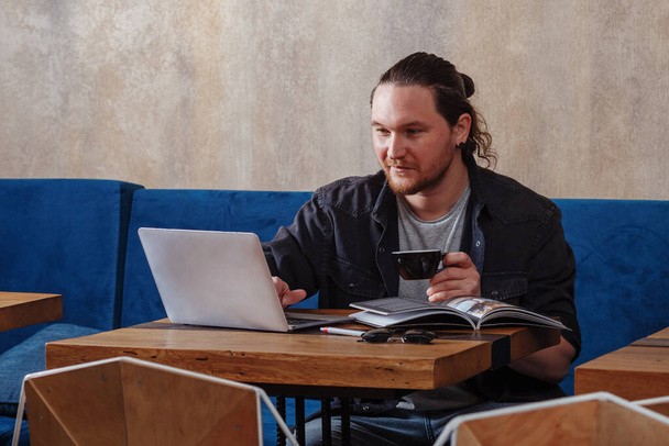 Sorrindo europeu usando laptop sentado à mesa no café, feliz proprietário do negócio animado olhando para a tela do computador satisfeito lendo boas notícias conversando em redes sociais
 - Foto, Imagem